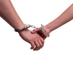 Man and woman holding hands in handcuffs - relationship concept