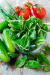 Fresh spinach , cucumbers and tomatoes on a wooden table