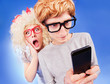 Foto: Girl is spying on boyfriend he is using a smart phone Girl is spying on boyfriend he is using a smart phone