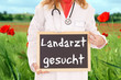 Ärztin mit Schild - Landarzt gesucht