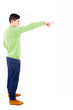Young man pointing towards copyspace, isolated on a white backgr