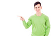 Happy smiling young man pointing towards copyspace, isolated on