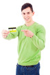 Photo: Smiling young man pointing to credit card on white background Smiling young man pointing to credit card on white background