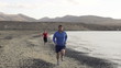 Man and woman jogging on the beach, super slow motion