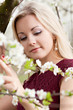 Beautiful blonde woman in blooming spring garden
