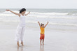 Photo: Mother and daughter walking along tropical beach Mother and daughter walking along tropical beach