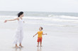 Photo: Mother and daughter walking along tropical beach Mother and daughter walking along tropical beach