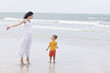 Photo: Mother and daughter walking along tropical beach Mother and daughter walking along tropical beach