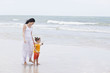 Photo: Mother and daughter walking along tropical beach Mother and daughter walking along tropical beach
