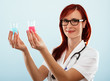 Portrait of a smiling female doctor holding flasks