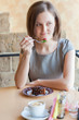 A woman in a restaurant is drinking coffee