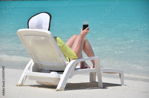 Photo: Girl with a glass of soda on the tropical beach Girl with a glass of soda on the tropical beach