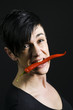 red chilli in the mouth of woman