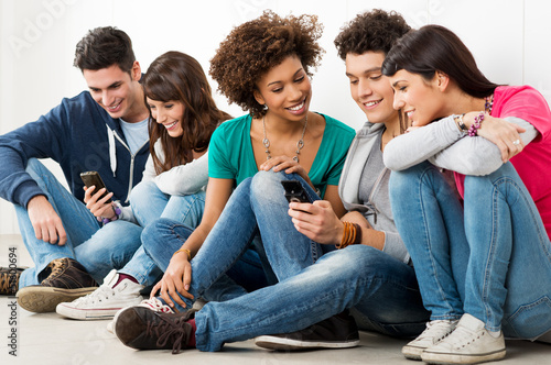Photo: Friends Looking At Cell Phone Friends Looking At Cell Phone