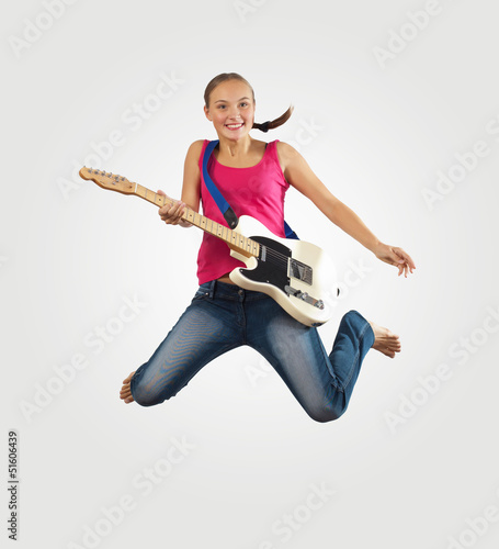 Photo: young woman playing on electro guitar and jumping young woman playing on electro guitar and jumping