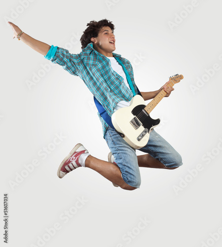 Photo: young man playing on electro guitar and jumping young man playing on electro guitar and jumping