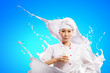 Asian female cook against milk splashes