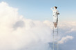 Photo: Businesswoman standing on ladder Businesswoman standing on ladder
