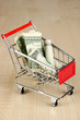 Money in cart on wooden table close-up