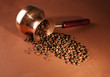 Coffee pot with coffee beans on brown background