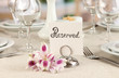 Reserved sign on restaurant table with empty dishes and glasses