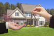 Photo: Agent Handing Over the House Keys in Front of New Home Agent Handing Over the House Keys in Front of New Home