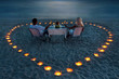 A young couple share a romantic dinner on the beach