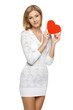 Photo: Smiling woman in white lacy dress holding heart shape Smiling woman in white lacy dress holding heart shape