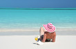 Girl with a glass of orange juice on the beach of Exuma, Bahamas