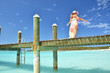 Girl on the wooden jetty making soap bubbles. Exuma, Bahamas