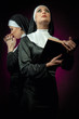 Two attractive young nuns with beads and bible praying