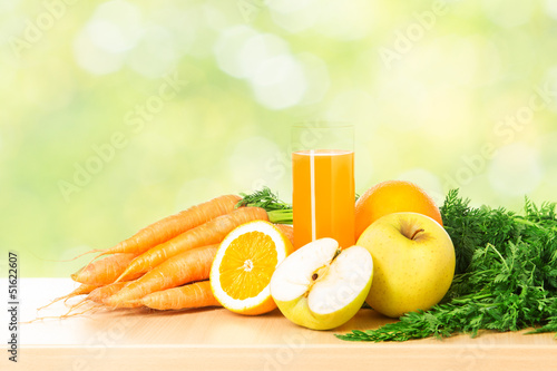 Photo: Fruit and vegetable juice in glass over green fresh background. Fruit and vegetable juice in glass over green fresh background.