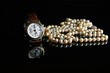 Armbanduhr und Perlen