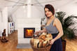 lady with firewood in front of a fireplace