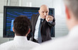 Angry boss pointing his finger at his employee during a meeting.