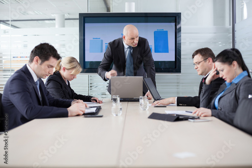 Photo: Manager yelling at his employees at the meeting. Company is in r Manager yelling at his employees at the meeting. Company is in r