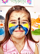 Foto: Child with face painting in play room. Child with face painting in play room.