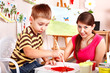 Foto: Child with teacher draw paints in play room. Child with teacher draw paints in play room.