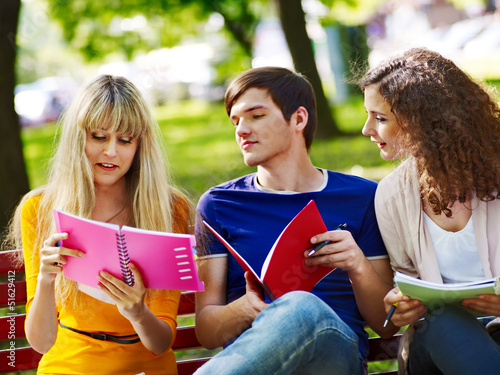 Photo: Group student with notebook on bench outdoor. Group student with notebook on bench outdoor.