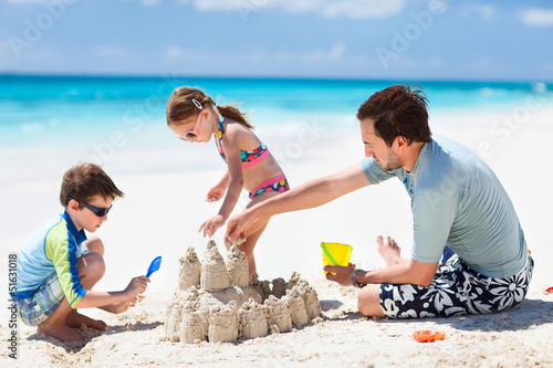 Photo: Father and kids playing at beach Father and kids playing at beach
