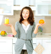 Funny Woman Choosing between Orange Juice or Whole Orange