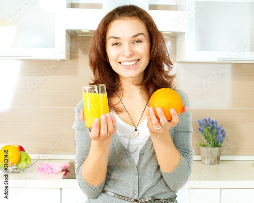 Photo: Healthy Girl with Orange Juice in the Kitchen Healthy Girl with Orange Juice in the Kitchen