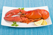 Lobster and lemon wedges on a blue background.