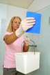 Frau putzt die  Dusche mit Putzlappen