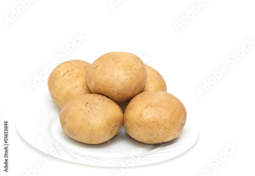 Photo: fresh potatoes on the plate on white background fresh potatoes on the plate on white background
