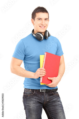 Photo: A handsome student with headphones holding books A handsome student with headphones holding books