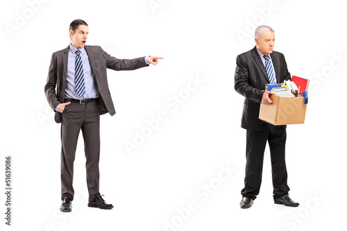 Photo: Full length portrait of an angry boss firing an employee Full length portrait of an angry boss firing an employee