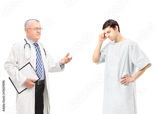 Photo: Mature doctor talking to a worried male patient Mature doctor talking to a worried male patient
