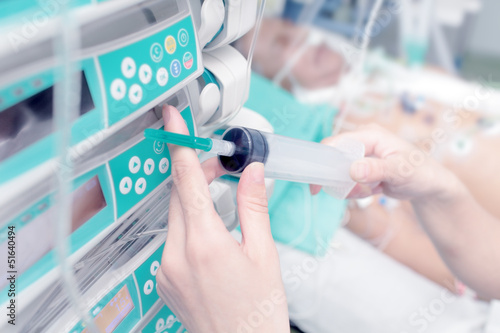 Photo: Syringe in the hand of a nurse on the background of the patient Syringe in the hand of a nurse on the background of the patient