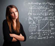 Beautiful school girl thinking about complex mathematical signs